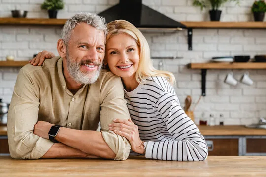 Midlife couple smiling in their kitchen