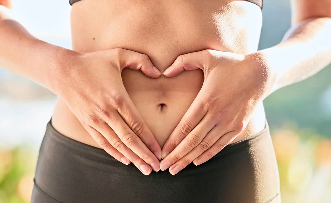 Hands forming a heart shape over the stomach
